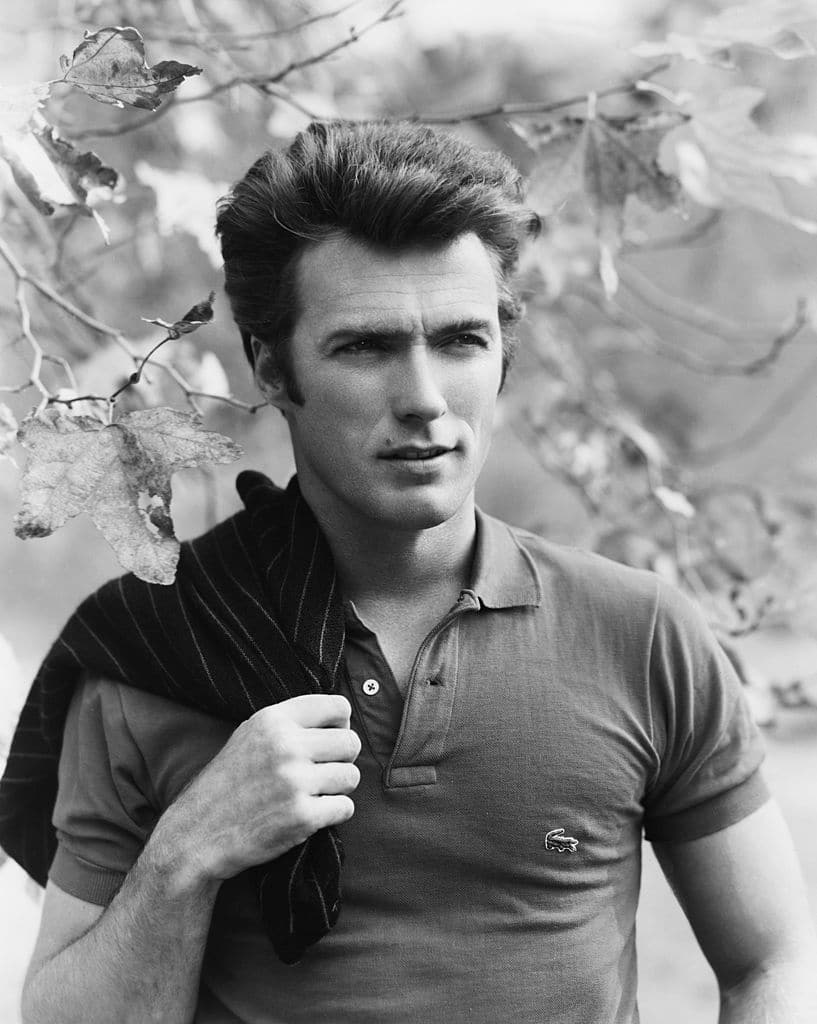 老式的克林特·伊斯特伍德（Clint Eastwood）穿着马球远处的脸，肩膀上的外套。