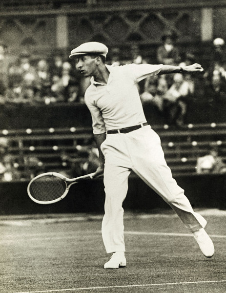 Vintage Rene Lacoste在人群面前打网球。